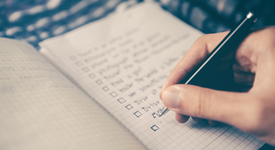 A person writing a checklist